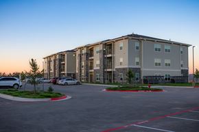 Kerrville apartment for rent - A parking lot in front of a large apartment building.