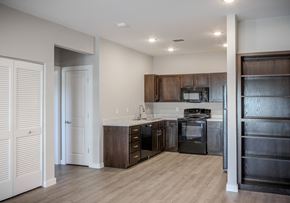 Kerrville apartment for rent - A modern kitchen with dark wood cabinets and stainless steel appliances.