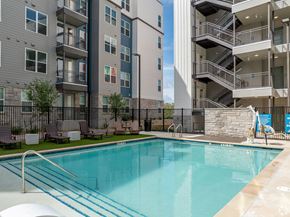 Austin apartment for rent - A swimming pool in front of apartment buildings.