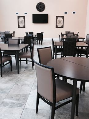 Punta Gorda apartment for rent - A room with tables and chairs and a clock on the wall.