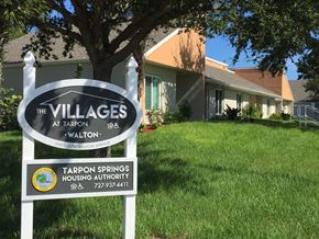 Tarpon Springs apartment for rent - A sign for The Villages at Tarpon Walton in front of a house.