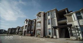 Abilene apartment for rent - A row of modern apartment buildings with a clear blue sky above.