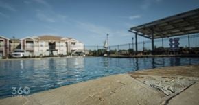 Abilene apartment for rent - A view of a pool with a building in the background.