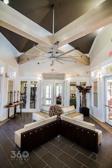 Abilene apartment for rent - A spacious living room with a large sectional sofa and a ceiling fan.
