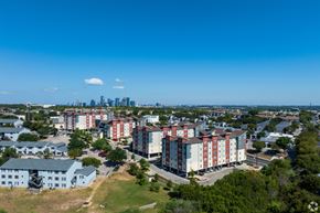 Austin apartment for rent - A view of a residential area with apartment buildings and a city skyline in the distance.