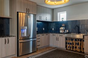 Austin apartment for rent - A modern kitchen with a stainless steel refrigerator and wooden cabinets.