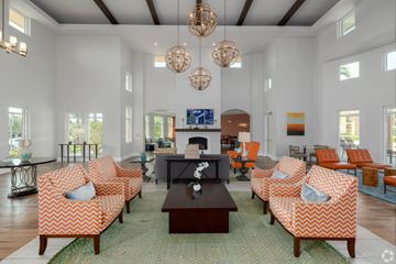 Fort Myers apartment for rent - A living room with orange and white patterned chairs and a fireplace.