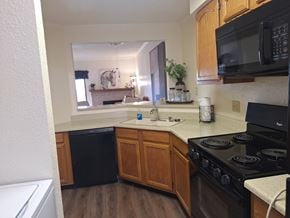 Abilene apartment for rent - A kitchen with a black stove top oven and wooden cabinets.