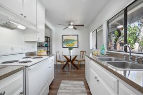 Westminster apartment for rent - a kitchen with white cabinets and a sink and a window