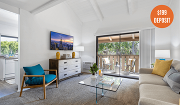 Westminster apartment for rent - A living room with a blue chair and a glass coffee table.