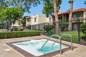 Westminster apartment for rent - a hot tub in a fenced in area with trees and a house