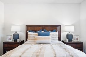 Fullerton apartment for rent - a bedroom with a bed with blue pillows and two lamps