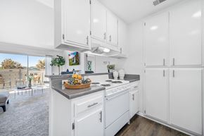 Anaheim apartment for rent - a white kitchen with white cabinetry and a counter top with a basket of fruit