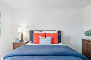 Anaheim apartment for rent - a bedroom with a blue bed and orange and blue pillows