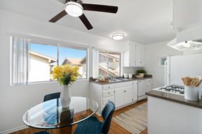 Tustin apartment for rent - an open kitchen and dining room with a glass table and chairs