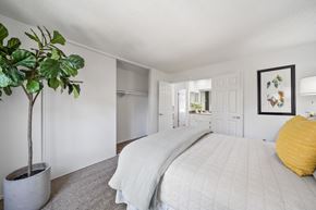 Fullerton apartment for rent - a white bedroom with a white bed and a potted plant