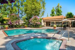 Orange apartment for rent - a swimming pool with a hot tub and a resort style building in the background