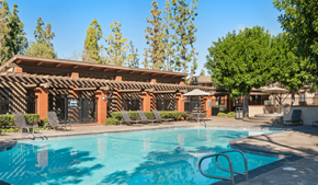 Irvine apartment for rent - A swimming pool in front of a building with a red tiled roof.