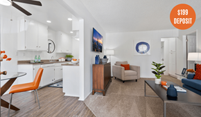 Tustin apartment for rent - A living room with a kitchen area in the background and a $199 deposit sign.