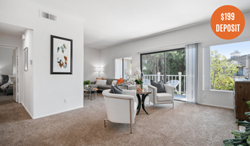 Costa Mesa townhouse for rent - A living room with a white sofa and a painting on the wall.