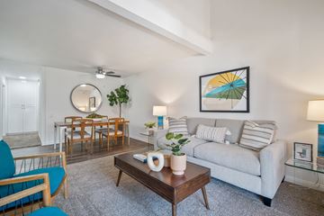 Fullerton apartment for rent - A living room with a grey couch, a wooden coffee table, and a painting on the wall.