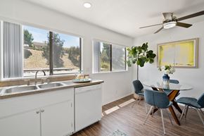 Rowland Heights apartment for rent - a kitchen with white cabinets and a dining room with a table and chairs