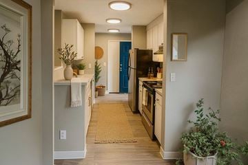 Burien apartment for rent - A kitchen with a blue refrigerator and wooden floors.