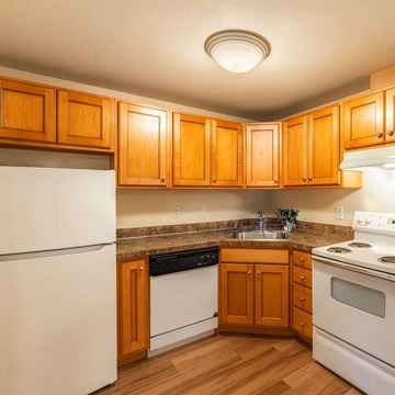 Tacoma apartment for rent - A kitchen with wooden cabinets and white appliances.