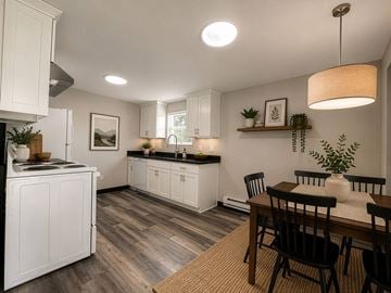 Fife apartment for rent - A kitchen with white cabinets and a wooden table.