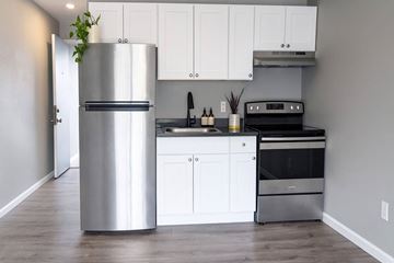 Tacoma apartment for rent - A modern kitchen with a stainless steel refrigerator and white cabinets.