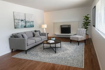 Lakewood apartment for rent - A living room with a grey couch, a coffee table, and a painting on the wall.