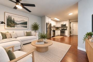 Seattle apartment for rent - A living room with a white couch and a painting of a forest scene on the wall.