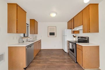 Bremerton apartment for rent - A kitchen with wooden cabinets and a white fridge.