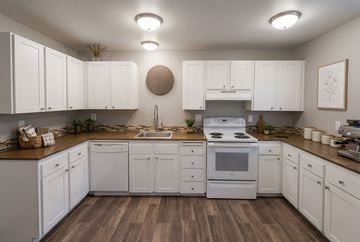 Poulsbo apartment for rent - A kitchen with white cabinets and a wooden floor.