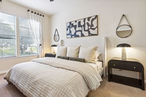 Gainesville apartment for rent - A bedroom with a large bed and a painting on the wall.