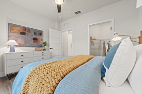 Orlando apartment for rent - A bedroom with a bed covered in a yellow and blue blanket.