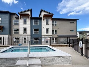 Eagle townhouse for rent - A modern two-story apartment building with a pool in the backyard.
