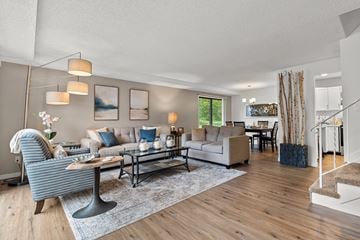 Plymouth townhouse for rent - A living room with a striped chair and a couch with pillows.
