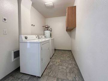 Moscow apartment for rent - A small white kitchen with a sink and a cabinet.