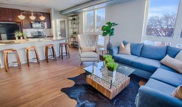 Fargo apartment for rent - A living room with a blue couch and a glass coffee table.