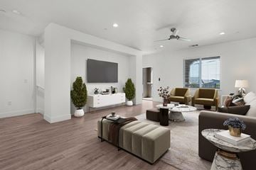 Roseville townhouse for rent - A living room with a brown sofa, a white couch, and a television on the wall.