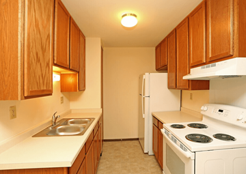 Hartland apartment for rent - A kitchen with white appliances and wooden cabinets.