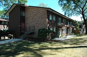 Milwaukee apartment for rent - A brown house with a red door and a balcony.