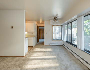 Milwaukee apartment for rent - A sunny day in a living room with a carpet floor and a ceiling fan.