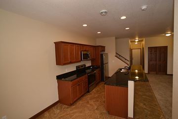 Waukesha apartment for rent - A kitchen with brown cabinets and black countertops.