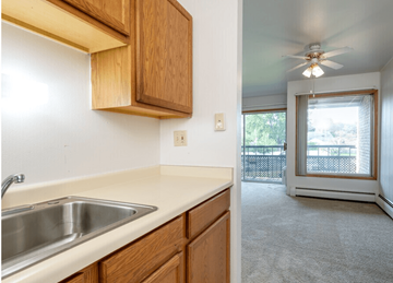 Milwaukee apartment for rent - A kitchen with wooden cabinets and a stainless steel sink.