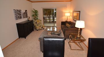 Milwaukee apartment for rent - A living room with a black leather chair and a gold side table.