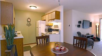 Kenosha apartment for rent - A kitchen area with a table and chairs in the foreground.