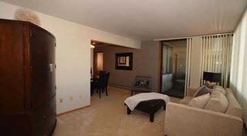 Milwaukee apartment for rent - A living room with a brown couch and a black chair.