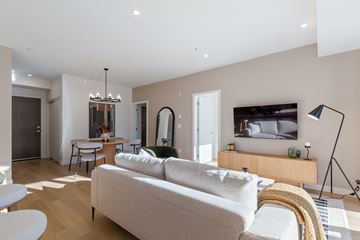 Abbotsford apartment for rent - A modern living room with a white sofa and a television.